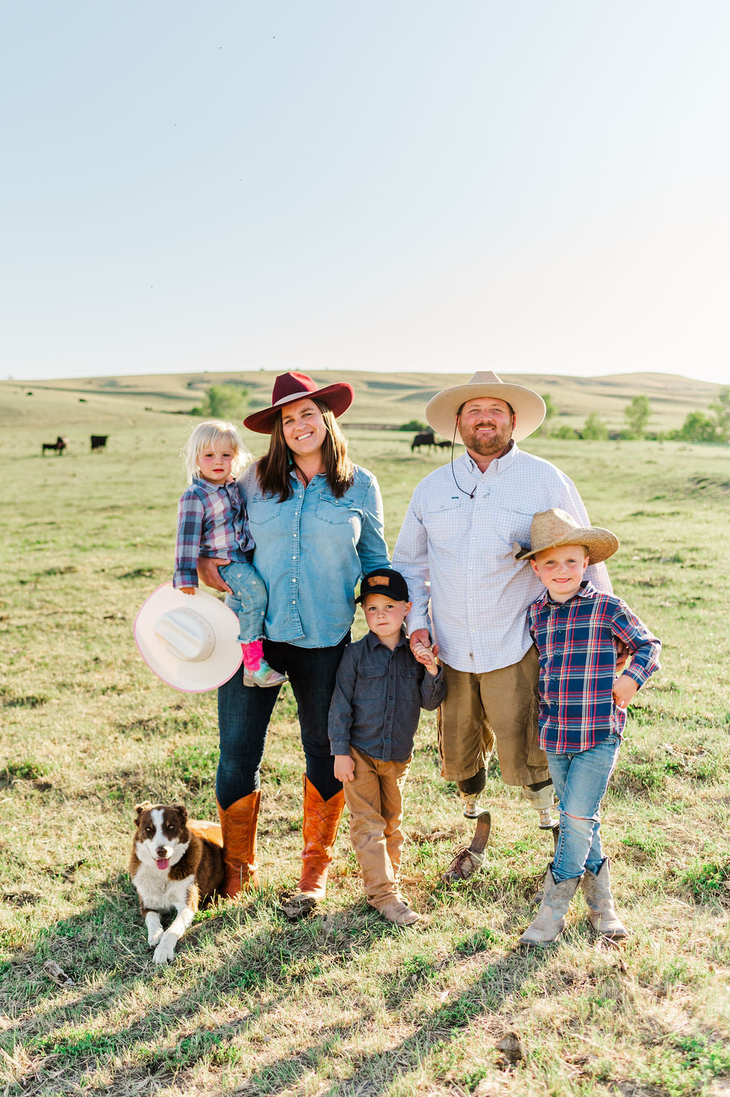 Family standing on a cow pasture on stick leg ranch